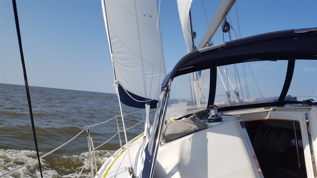 Image from the cockpit of a sailboat which is heeled over to the left