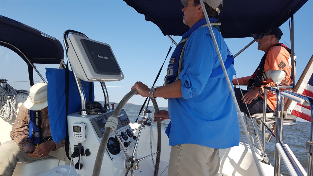 Image of helmsman and crew in the boat