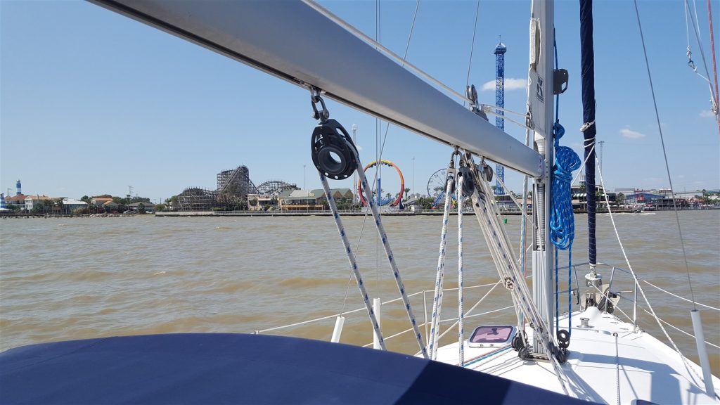 Image of Kemah Boardwalk in the distance, taken from the front of a sailboat on the water