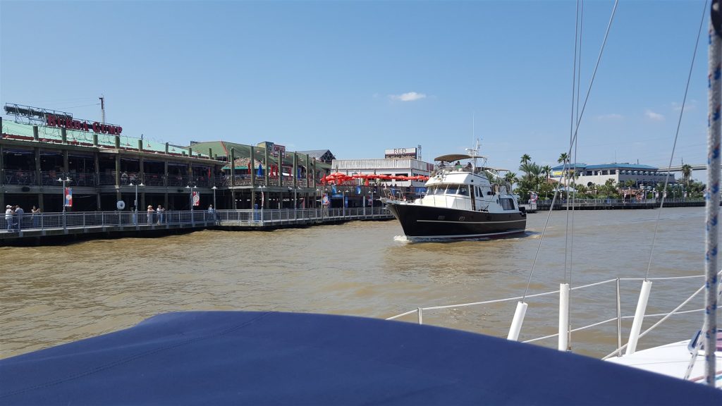 Image of the Kemah boardwalk taken from the water, while passing a motor yacht