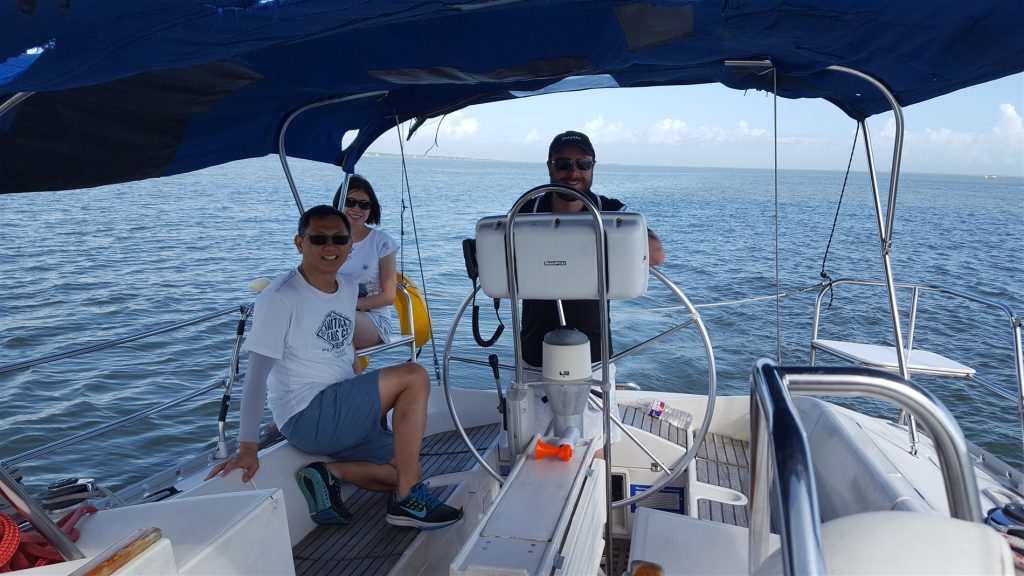 Photo of crew in a sailboat on the water