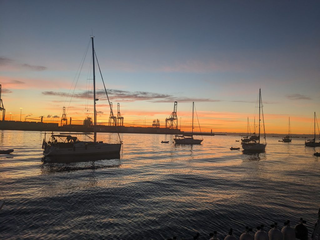 Image of multiple sailboats anchored at sunrise