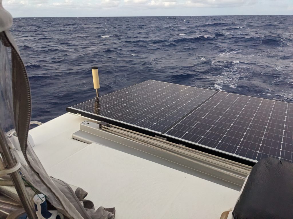 Image of solar panel mounted on the stern of a boat, with an antenna sticking up on one end