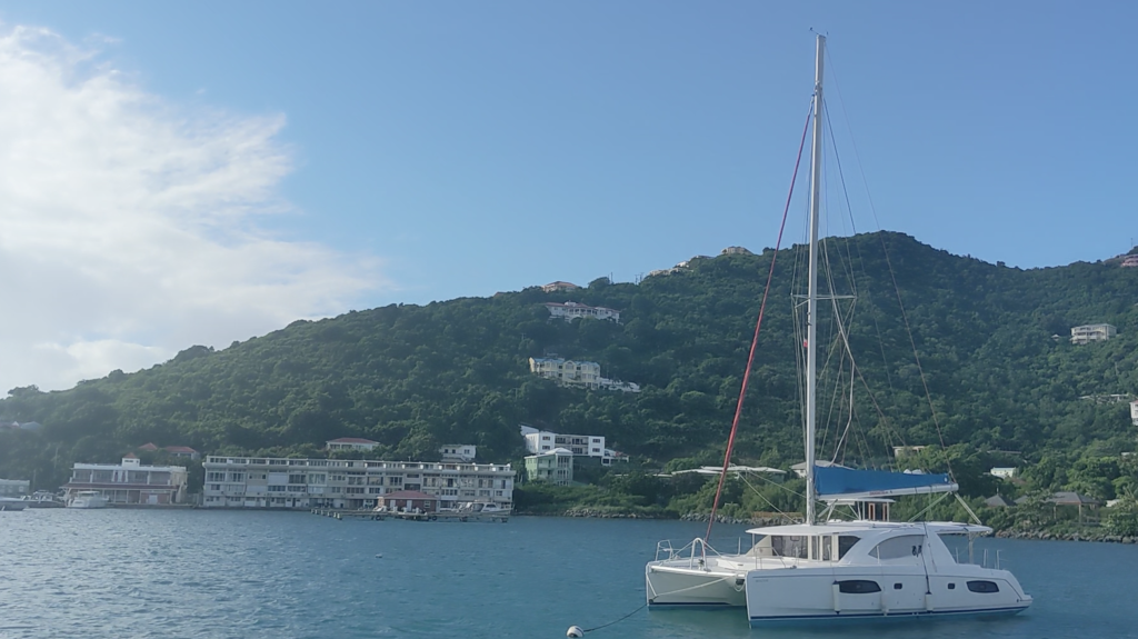Image of a moored sailboat with the foothills of Tortola in the background
