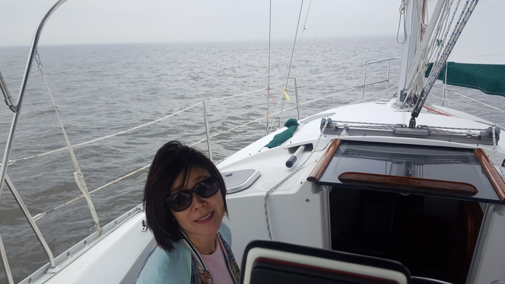 Image of woman seated in a boar which is at sea