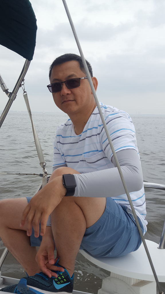 Image of man seated, looking relaxed on a boat at sea