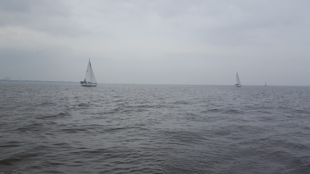 Image of the ocean with sailboats in the distance