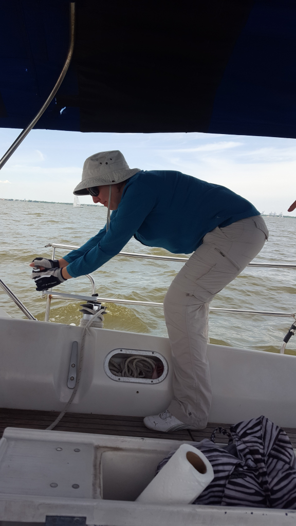 Image of woman cranking on a winch on a sailboat at sea