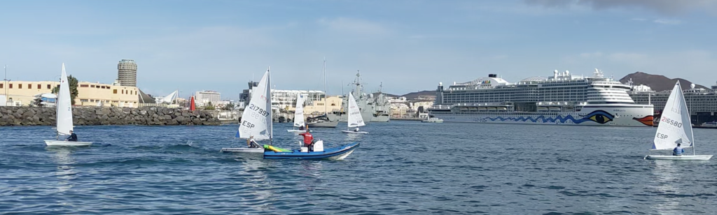 Image of several dinghy sailboats sailing in a protected bay